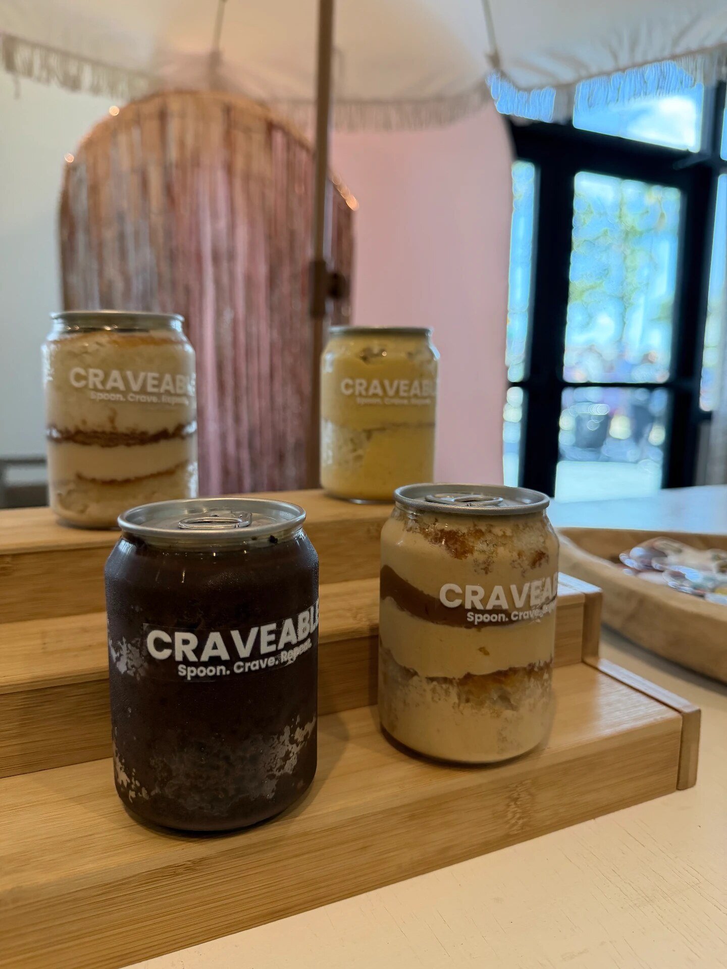 Four flavored cans on a two-tier wooden riser